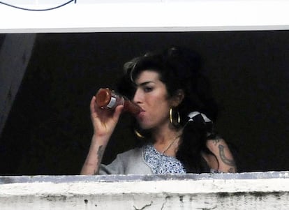 Amy Winehouse aparece en una ventana de su casa en Candem bebiendo una cerveza, el 20 de marzo de 2010
