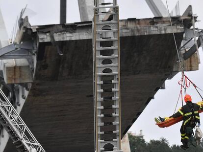 Rescatitas recuperan una víctima entre los escombros del puente en Génova.