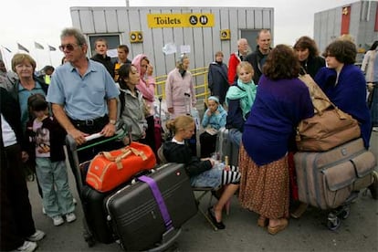 Un grupo de pasajeros hace cola para facturar su equipaje en la terminal 4 del aeropuerto londinense de Heathrow.