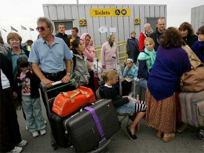 Un grupo de pasajeros hace cola para facturar su equipaje en la terminal 4 del aeropuerto londinense de Heathrow.