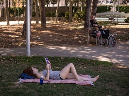 Una mujer lee en un parque de Barcelona.