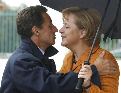 La canciller alemana Angela Merkel y el expresidente francés Nicolas Sarkozy pasean debajo de un paraguas a su llegada durante un encuentro en el palacio de Meseberg, al norte de Berlín (Alemania), el 10 de septiembre de 2007.