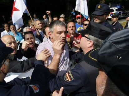 El alcalde de San Sadurniño, Secundino Casal (BNG), se encara a los agentes de la Policía Nacional que retienen la protesta durante el acto.