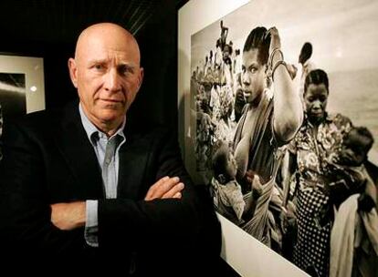 Sebastião Salgado posa junto a una de sus fotografías ayer en Madrid.