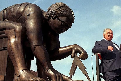 Eduardo Paolozzi, junto a su escultura de Isaac Newton en la biblioteca británica, en Londres.