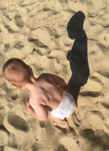 Un beb&eacute; juega en una playa gallega.