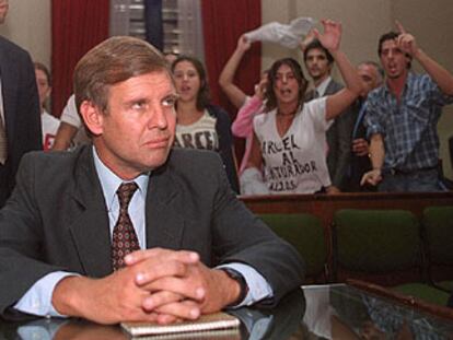 El ex capitán Alfredo Astiz espera el inicio de un juicio en 2000 en Buenos Aires, ante las protestas de un grupo de jóvenes.