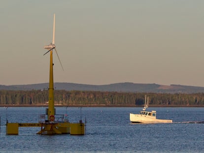 A lobster boat passes the country's first floating wind turbine off the coast of Castine, Maine, Sept. 20, 2013.