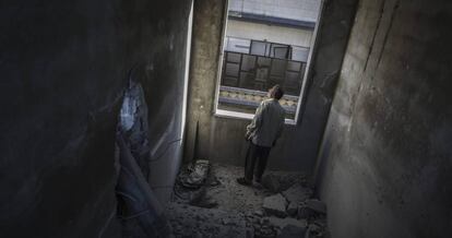 Un hombre observa los da&ntilde;os causados por una bomba en Duma, en las afueras de Damasco, Siria.