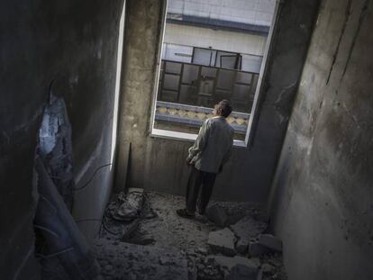 Un hombre observa los da&ntilde;os causados por una bomba en Duma, en las afueras de Damasco, Siria.