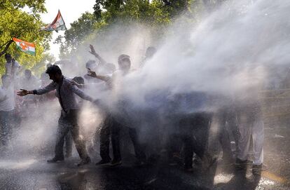 Los activistas del Congreso de la Juventud de la India (IYC, por sus siglas en inglés) son golpeados con un cañón de agua de la policía durante una protesta, en Nueva Delhi (India).