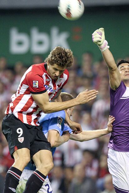 El delantero del Athletic Llorente intenta un remate ante el portero de Osasuna Andrés Fernández.