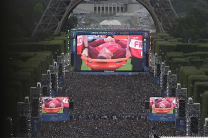 Una multitud de gente mira en una pantalla gigante la final de la Eurocopa 2016 entre Portugal y Francia, mientras el delantero Cristiano Ronaldo es trasladado en una camilla, el 10 de julio de 2016, en París (Francia).