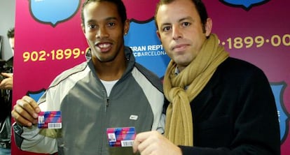 Ronaldinho y Sandro Rosell con el carnet de socio del F.C. Barcelona.