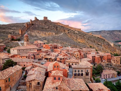 Albarracín (Teruel). Tres castillos y dos murallas, una de ellas larguísima. Abajo, el foso curvo y profundo del río Guadalaviar. Arriba, el castillo más alto, la torre califal del Andador, del siglo X. Y a media altura, junto al Portal de Molina, la casa de la Julianeta, que data del siglo XIV pero parece mucho más moderna, de la época cubista, por su perspectiva caprichosa: tan ladeada está que parece que va a derrumbarse. No solo la casa de la Julianeta: todo Albarracín se inclina porque es una pura cuesta, no apta para circular en coche ni para andar con tacones. Avisados quedan.