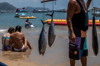 Un pescador recorre las playas en busca de clientes para vender la pesca del día.