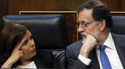 El presidente del Gobierno, Mariano Rajoy, habla con la vicepresidenta, Soraya S&aacute;enz de Santamar&iacute;a, durante el pleno del Congreso.