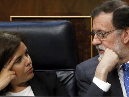 El presidente del Gobierno, Mariano Rajoy, habla con la vicepresidenta, Soraya S&aacute;enz de Santamar&iacute;a, durante el pleno del Congreso.