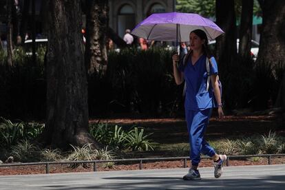 Una joven camina bajo la sombra de un paraguas en la Alameda Central de Ciudad de México, el pasado 9 de junio. 