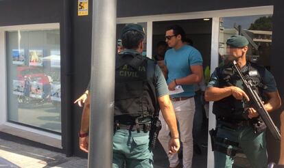 The Civil Guard escorts the owner of the real estate agency after his arrest.