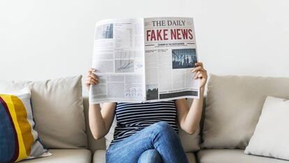 Una mujer leyendo un periódico.