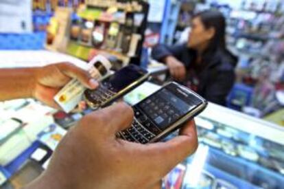 Un cliente sostiene dos teléfonos móviles BlackBerry en una tienda de un centro comercial en Yakarta (Indonesia). EFE/Archivo