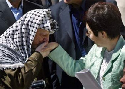 Arafat besa la mano de la ministra de Exteriores japonesa, Yoriko Kawaguchi, en su cuartel general de Ramala.