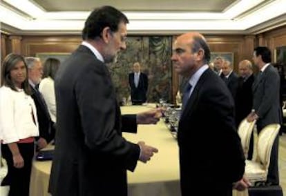 El presidente del Gobierno, Mariano Rajoy (i), conversa con el ministro de Economía y Competitividad, Luis de Guindos. EFE/Archivo