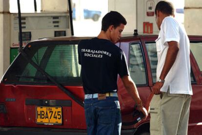 Un trabajador social despacha gasolina en una estación en La Habana.