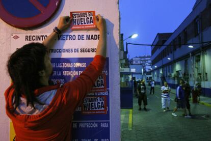 Un trabajador de Metro coloca un cartel durante una de las jornadas de huelga.