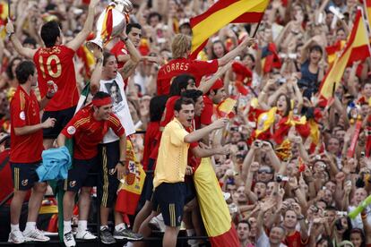 Los componentes de la selección saludan desde el autobús descubierto a los aficionados que les arropan por las calles de Madrid.