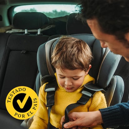 Un padre poniéndole el cinturón a su hijo en el coche.