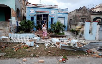 Em vários bairros a energia já era cortada antecipadamente por precaução, mas ia sendo reposta à medida que as condições melhoravam. Na imagem, uma mulher observa os danos causados a uma casa em Havana, depois do tornado.