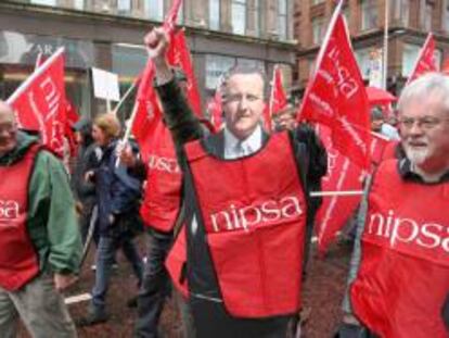 Un sindicalista de Irlanda del Norte (c) porta un recorte del primer ministro británico, David Cameron durante una manifestación ayer contra el G8 en la ciudad de Belfast, Irlanda del Norte.