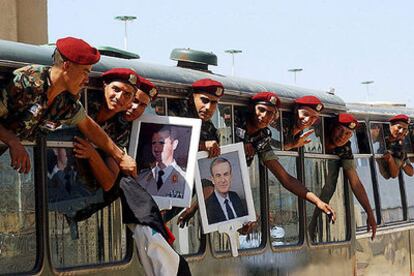 Militares sirios muestran retratos del presidente Bachar el Asad y de su padre, Hafez, durante su retirada de Líbano la semana pasada.