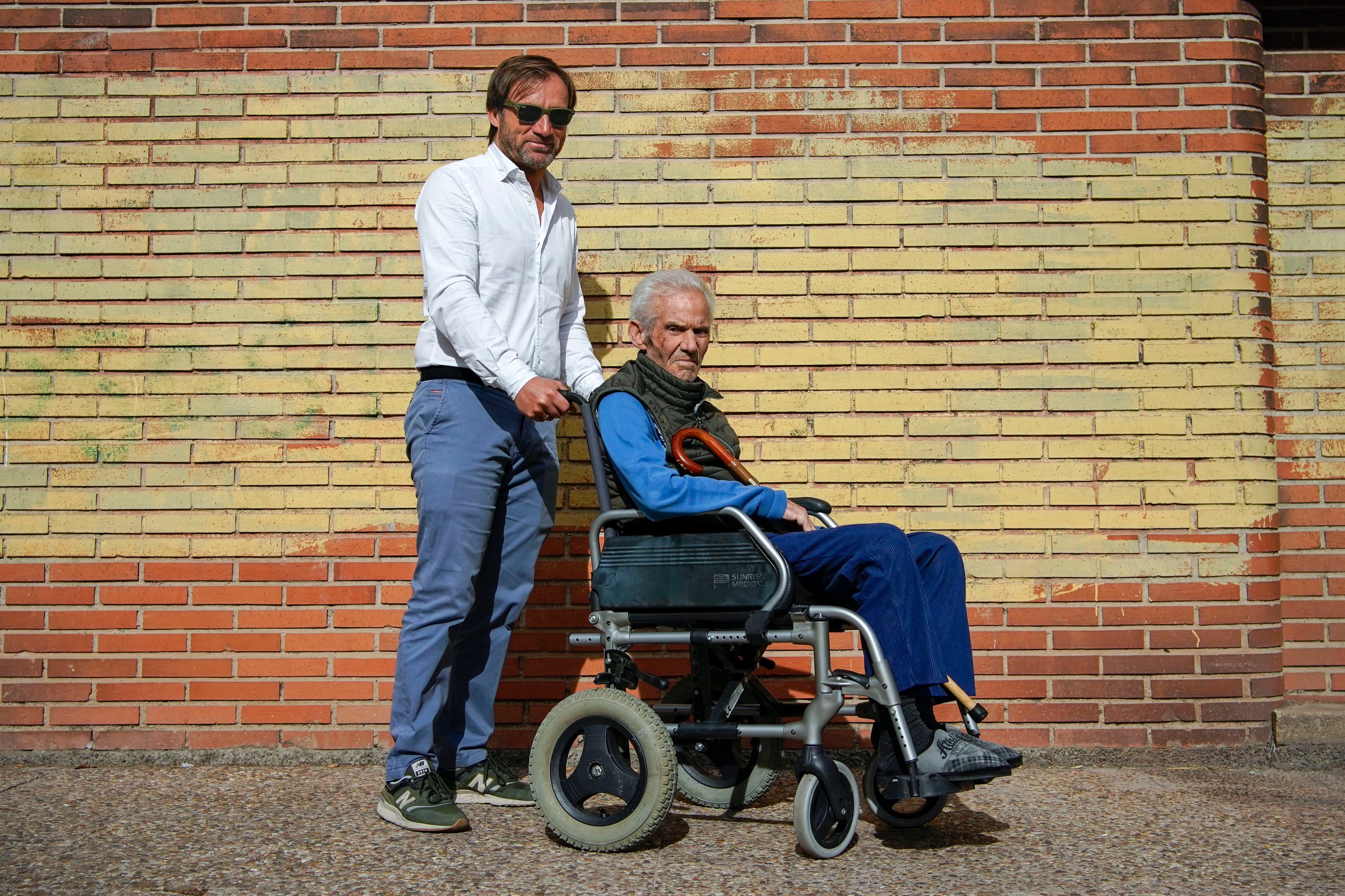 El voluntario de paliativos David Mínguez posa junto a Domingo cerca de su casa en Madrid. 