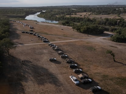 Vehículos militares y de las fuerzas del orden crean un cordón alrededor de los migrantes que se refugian en un campamento fronterizo improvisado en Del Rio, Texas.