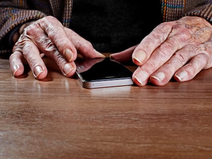 Un hombre mayor observa un 'smartphone'.