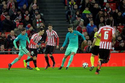 Aduriz golpea la pelota ante Piqué.