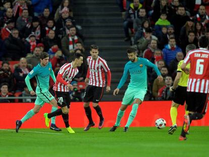 Aduriz golpea la pelota ante Piqué.