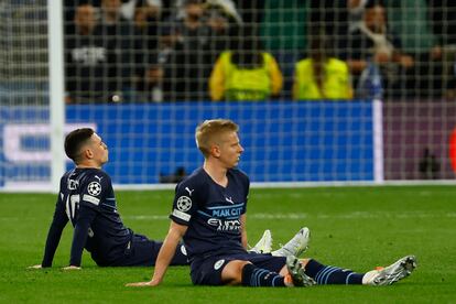 Los jugadores del Manchester City, Phil Foden (izquierda) y el ucraniano Alexander Zinchenko, decepcionados tras la finalización del encuentro correspondiente a la vuelta de las semifinales de la Liga de Campeones que han disputado hoy miércoles frente al Real Madrid en el estadio Santiago Bernabéu, en Madrid. 
