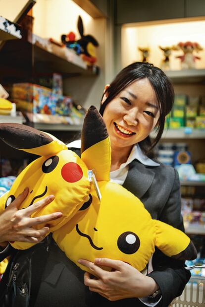 Una compradora sostiene dos peluches con la cara de Pikachu, el personaje más icónico de Pokémon.