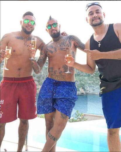 Mezclar copas de champán, gafas de espejo, crestas y rapados, tatuajes y cadenas en un balcón acristalado con vistas a una cala paradisíaca raya el mal gusto. Aunque el aguerrido jugador de Bayern de Munich, Arturo Vidal (30 años, Chile) -que está en el centro en la imagen-, no lo crea, es posible disfrutar del verano sin emular a los personajes de la serie de 'Narcos'.