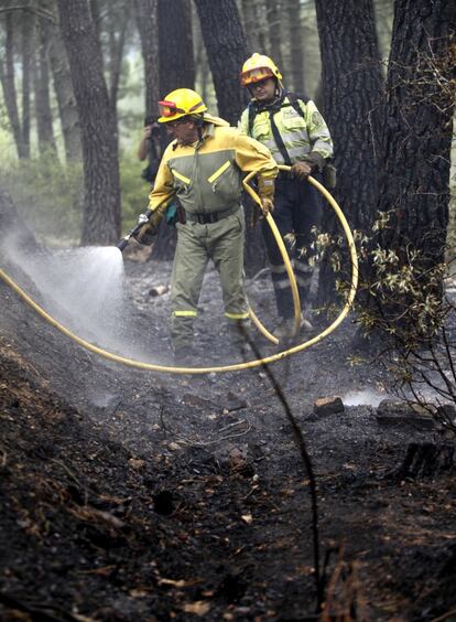 Los bomberos enfrían la zona afectada por el incendio en Guadalajara.