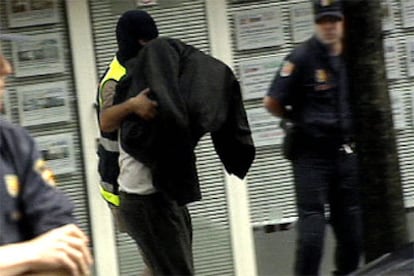 Un agente traslada a uno de los detenidos en la operación en Irún.