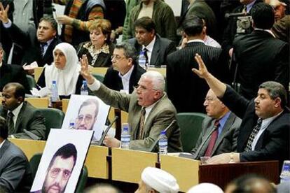 Diputados palestinos votan en la sesin de ayer junto a fotografas de legisladores encarcelados.