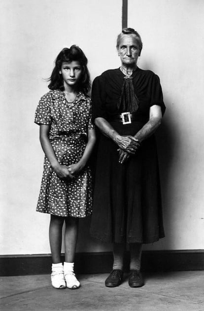 Una abuela y una nieta posando para Mike Disfarmer en la misma posición y con un semblante similar. En el fondo blanco la característica línea vertical que aparece en las imágenes de este fotógrafo y que articula las imágenes.