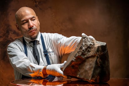 Un trabajador de Sotheby´s muestra el meteorito de Marte.