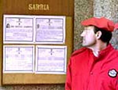 Un <i>ertzaina</i> observa, en la puerta del tanatorio de Algorta, la esquela de su compañera asesinada por ETA.