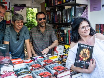 Jorge Díaz, Agustín Martínez y Antonio Mercero, bajo el seudónimo de Carmen Mola, durante la firma de libros en la Feria del Libro de Madrid el 1 de junio.